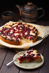 Homemade cherry pie with tea cup on wooden table