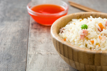 Fried chinese rice with vegetables on wooden background
