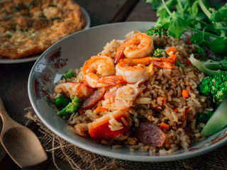 Vintage style Thai traditional food fried rice with shrimp on top and wooden background wallpaper
