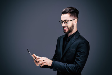 Portrait d'un jeune homme d'affaires souriant, tenant une tablette tactile dans ses mains