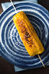 Roasted corn with salt on blue plate diagonal