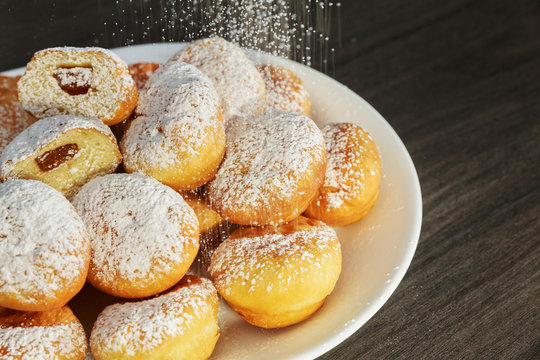 heap of marmalade filled bismarck donuts on white plate