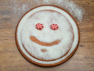 sugar face with eyes of variegated candy on a wooden stand