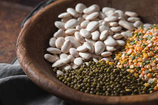 Placer green and white beans in a wooden bowl closeup
