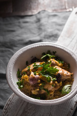 Pilaf with rice, chicken and raisins in a ceramic bowl