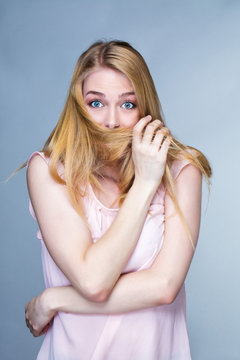 Portrait d'une jeune femme étonnée, les cheveux devant la bouche