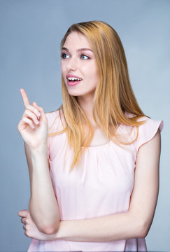 Portrait d'une jeune femme souriante, le doigt levé sur le coté