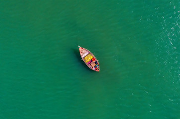 Fishing boat floating in the sea. The beautiful bright blue water in a clear day.Aerial view.Top view.