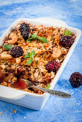 Freshly baked diet berry crumble with oatmeal with fresh berries blackberries decorated with mint...