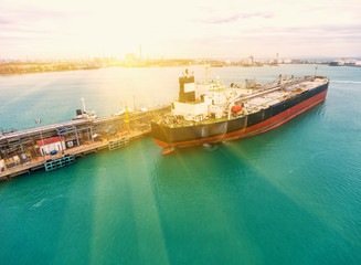 container ship in import export and business logistic.By crane , Trade Port , Shipping.Tugboat assisting cargo to harbor.Aerial view.