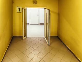 Bright yellow color stairway with the door open to an office corridor