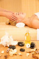 Obraz na płótnie Canvas Beautiful blonde woman having a face massage in spa salon