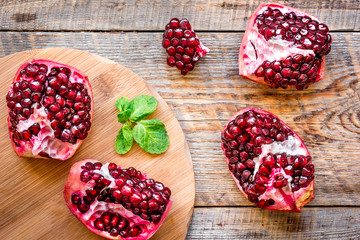 sliced pomegranate on wooden background top view