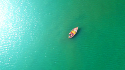 Fishing boat floating in the sea. The beautiful bright blue water in a clear day.Aerial view.Top view.