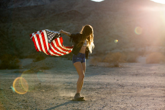 Woman in sunlight holding American flag
