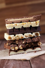 Chocolate bars on a wooden background with chocolate tower