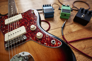 Naklejka premium an electric guitar with cables and pedals