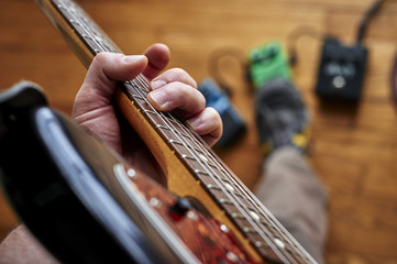 a person playing a guitar and using effect pedals