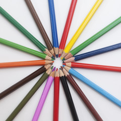 colored pencils laid out in a sun shape on a white background