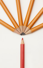 yellow pencils on white background and one red. The concept of differences.