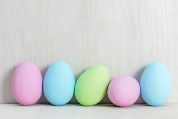 Pastel Easter eggs on wooden table.