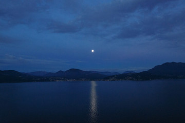 Beautiful evening landscape. Lunar path on lake and mountain