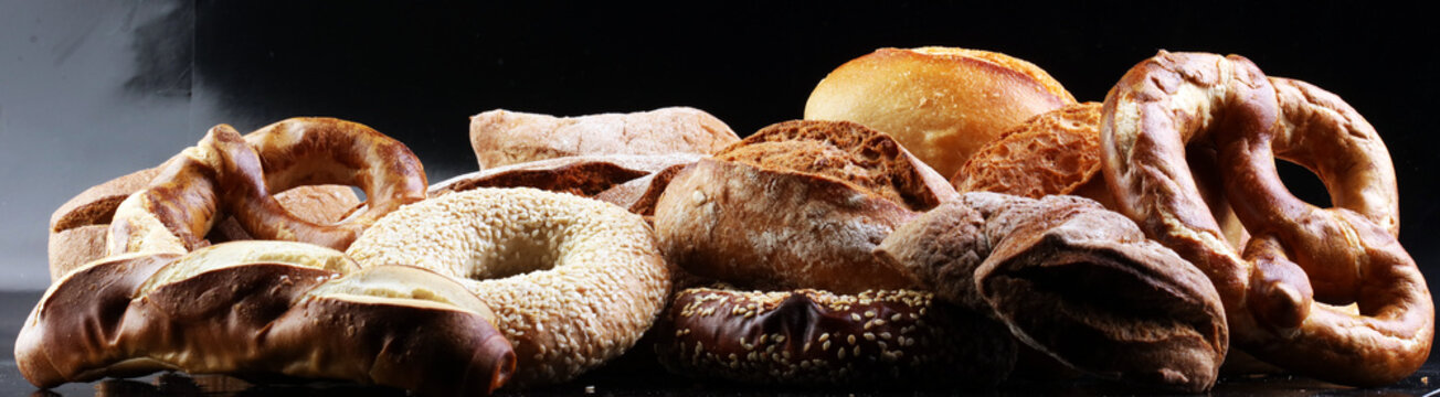 Different kinds of bread and bread rolls on board from above. Kitchen or bakery poster design.