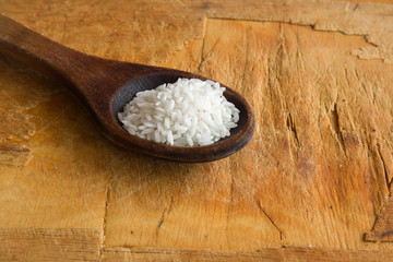 Rice in the wooden spoon on the wooden table. Healthy eating and lifestyle.
