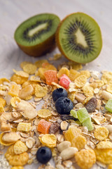 granola with blueberries in white bowl on wooden white background