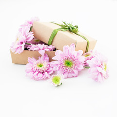 Obraz na płótnie Canvas Craft gift box and pink flower on white background. Flat lay, top view. Floral background.