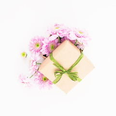 Craft paper gift box and pink flower on white background. Flat lay, top view. Love background.