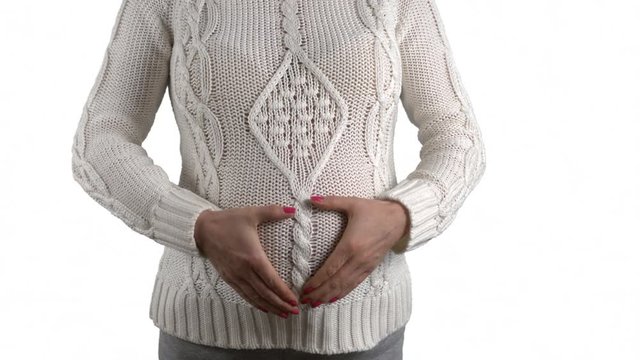 Pregnant woman in white sweater keeping hands on her belly on white background. Face hidden. 4k footage PNG with alpha channel