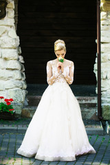 Obraz premium Cheerful girl or bride in white wedding dress with flower