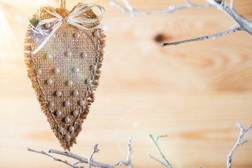 Heart made of cloth on white branch.