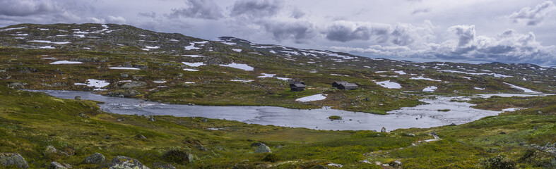 Panorama of river and mountains with small houses in Norway