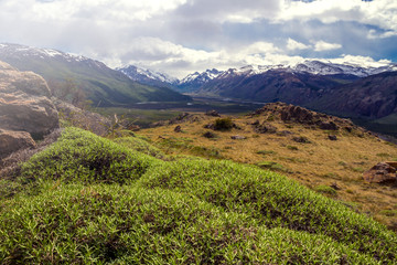 Beautiful landscape in patagonian mountains, green hill, blue sky and mountains.