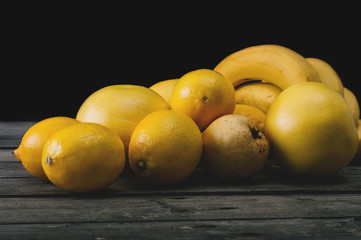 Bunch of fresh yellow fruit on an old wooden table. Selective focus and small depth of field.