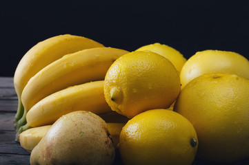 Bunch of fresh yellow fruit on an old wooden table. Selective focus and small depth of field.