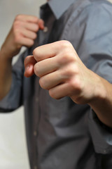 Fototapeta premium young man in boxing pose with fists up dressed nicely.
