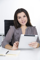 Cheerful woman in gray with a tablet