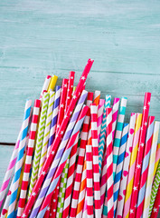 multicolored paper straws on turquoise wooden background