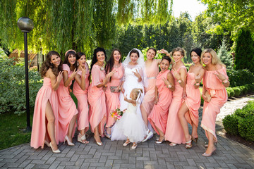 Bride, her little sister and stylish bridesmaids having fun at wedding day. Crazy wedding