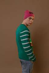 Cute guy in hipster clothes 90s posing in studio