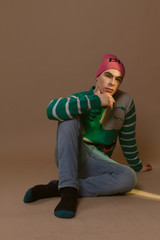 Cute guy in hipster clothes 90s posing in studio