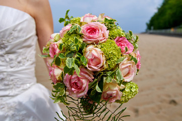 bride holding wedding bouquet with roses