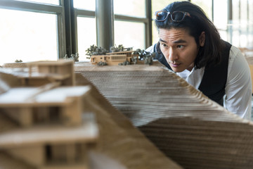 Lead architect designer reviews physical model of structure built in 3d 