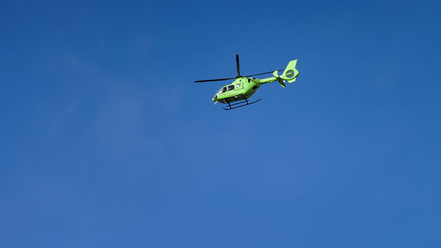 Un hélicoptère vert dans un ciel bleu