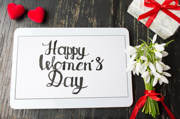 Happy womens day calligraphy note on a tablet