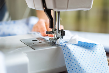 Woman working on sewing machine. Close up view