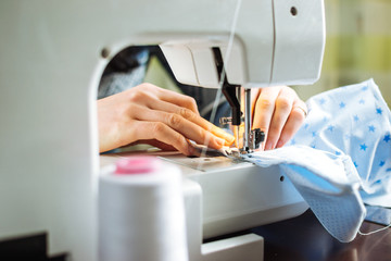 Obraz na płótnie Canvas Woman working on sewing machine. Close up view